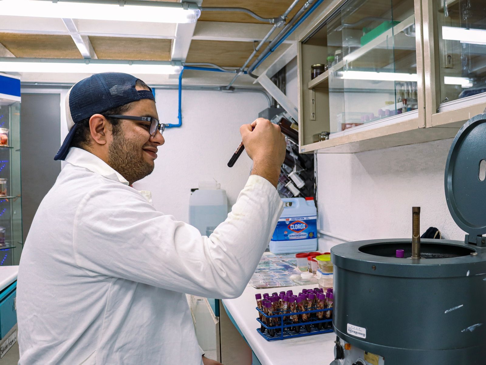 A scientist working with test tubes in a lab setting, focusing on scientific research.