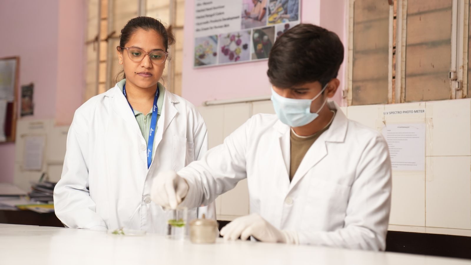 Two young scientists in lab coats performing an experiment in a laboratory setting.