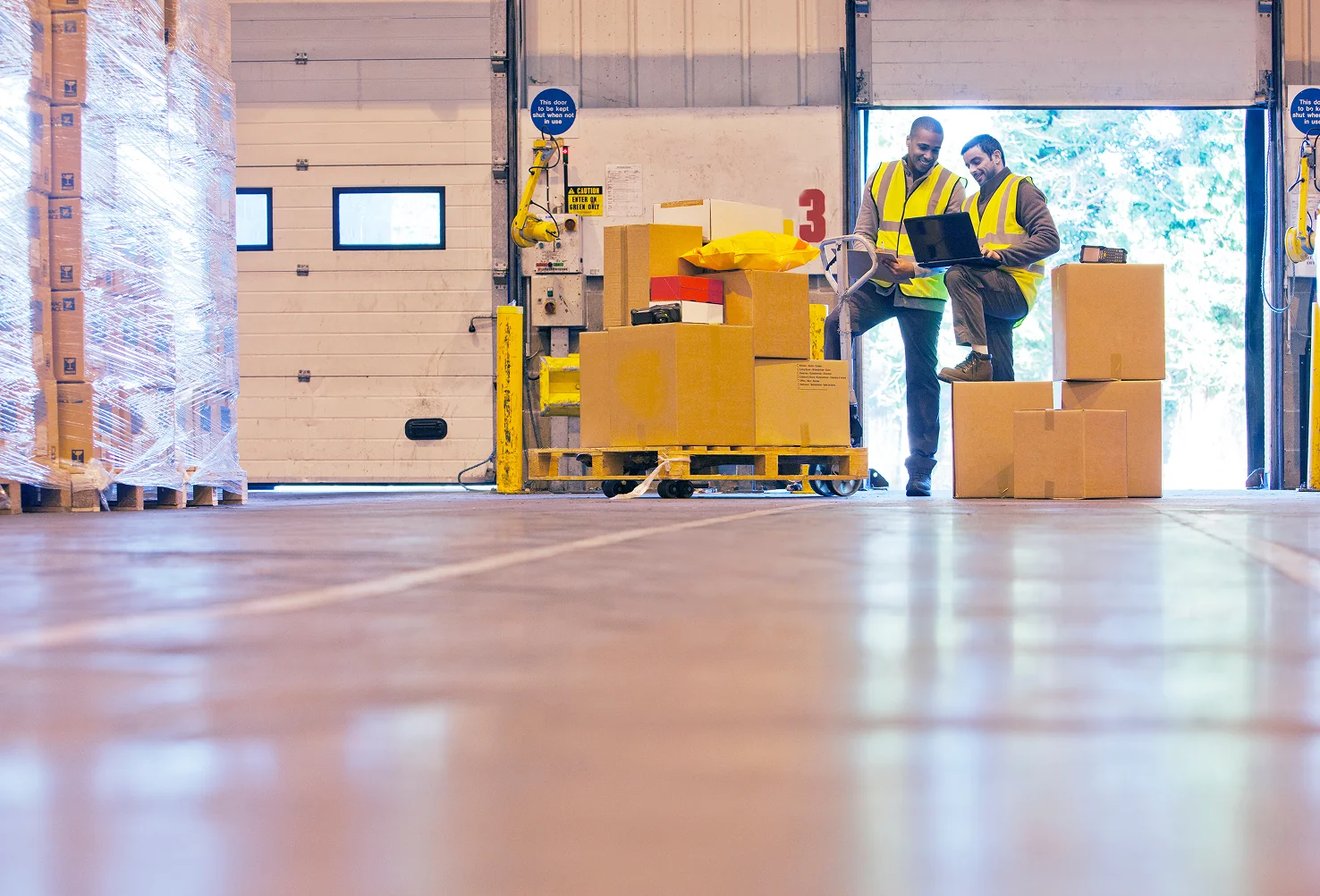 Two men moving boxes in a lab