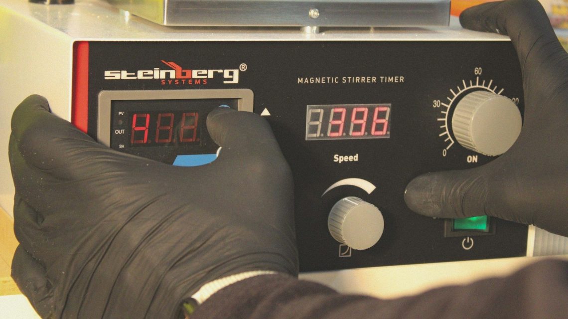 a person in black gloves is testing a machine