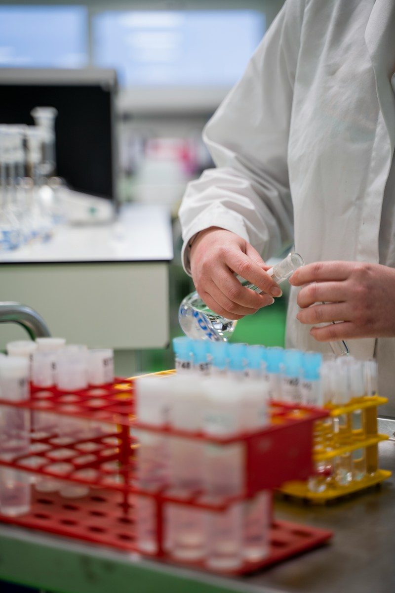 Researcher handling sample tubes in racks at a lab bench