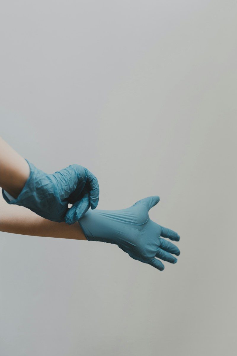 person putting on blue medical gloves