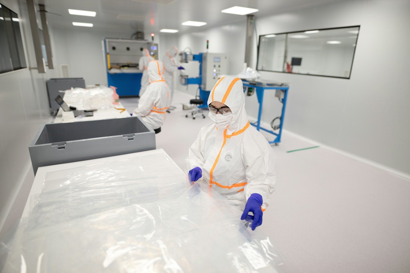 Workers in protective suits inside a cleanroom