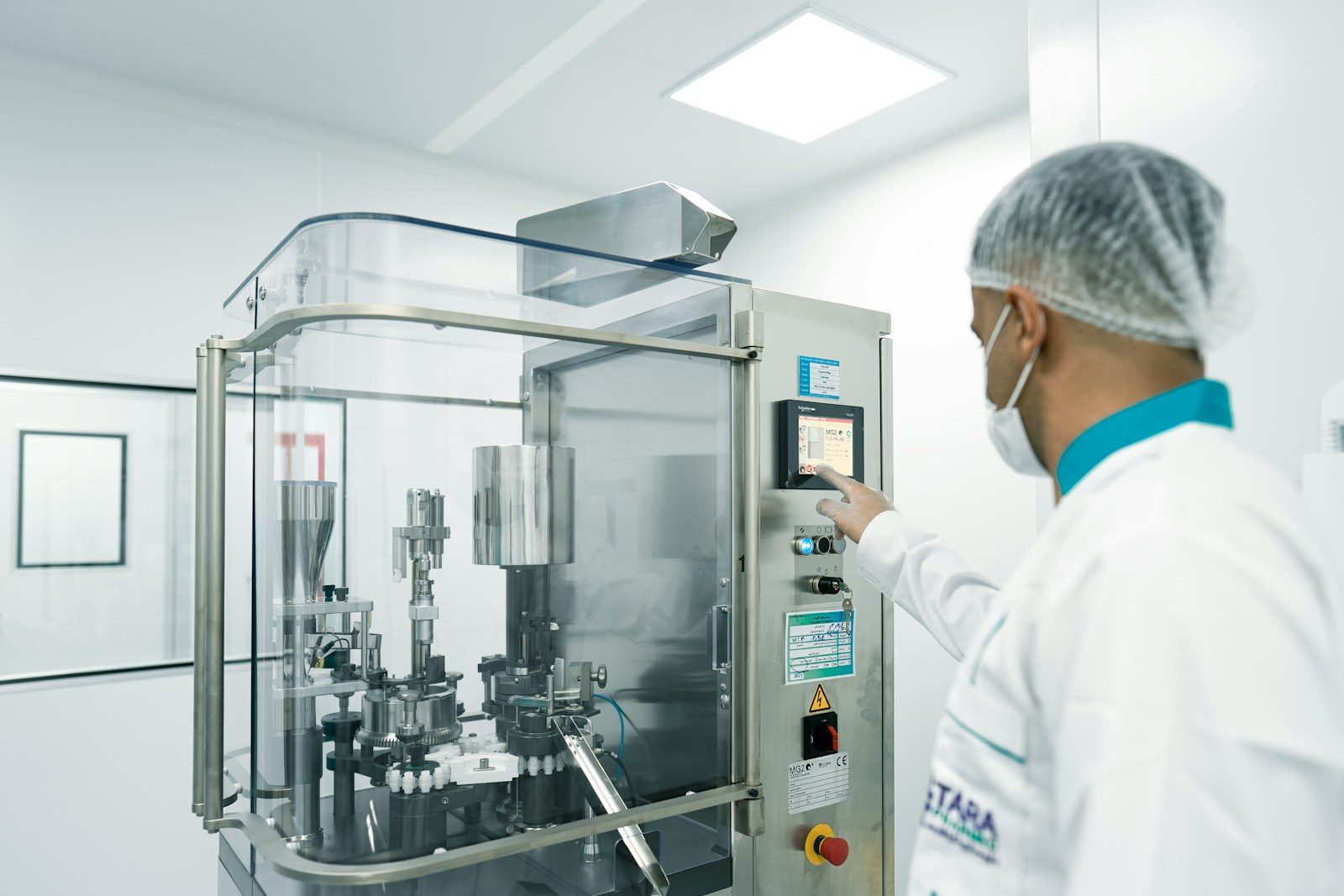 A worker operates machinery in a cleanroom