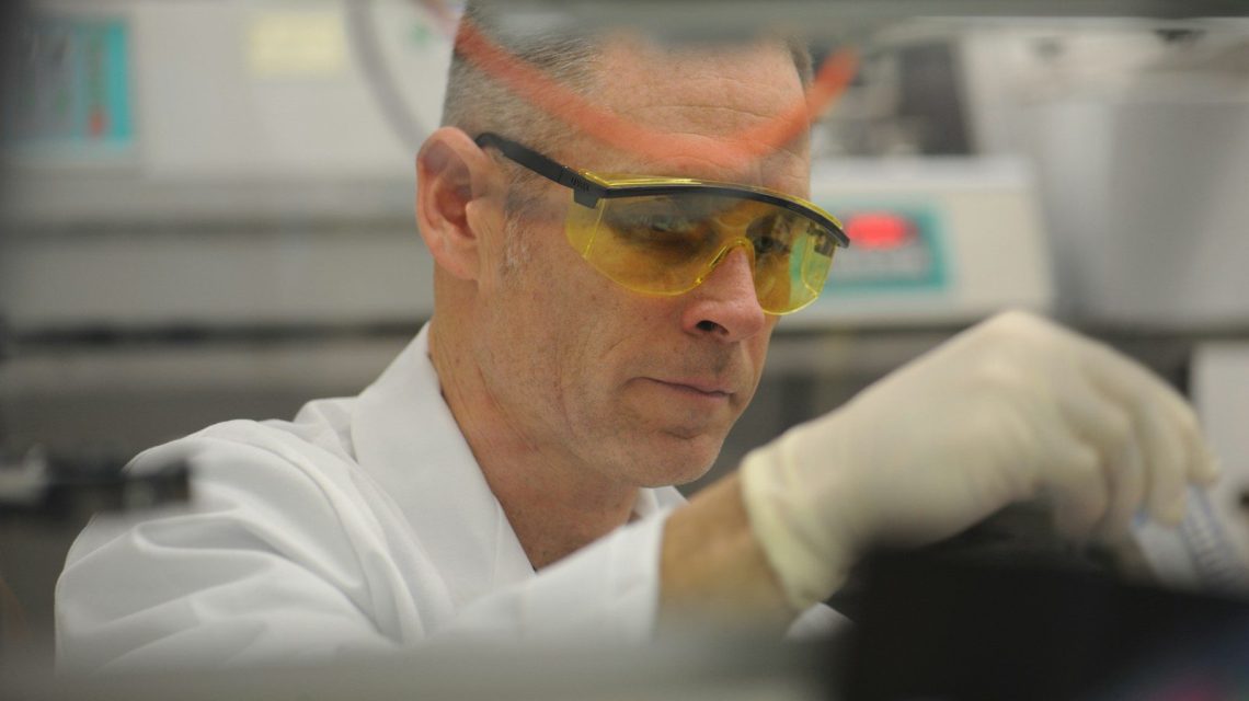 a man in a lab wearing safety goggles