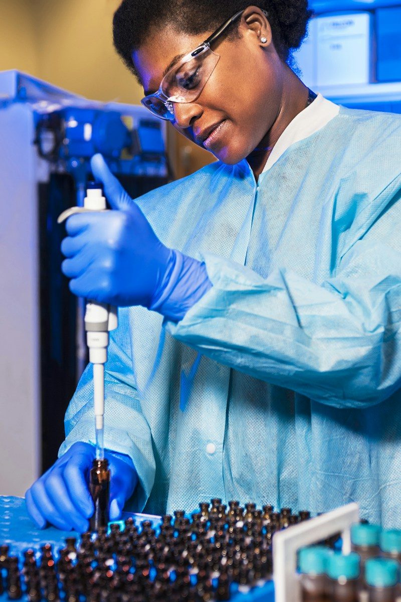 Scientist pipetting samples into vials in a lab