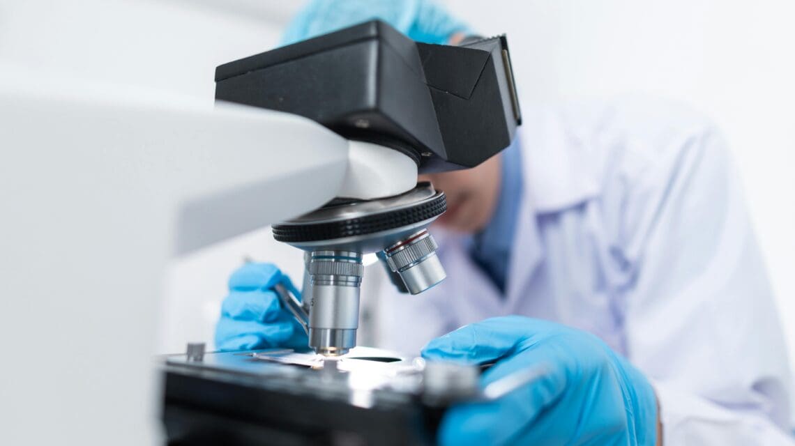 Scientist in lab using microscope