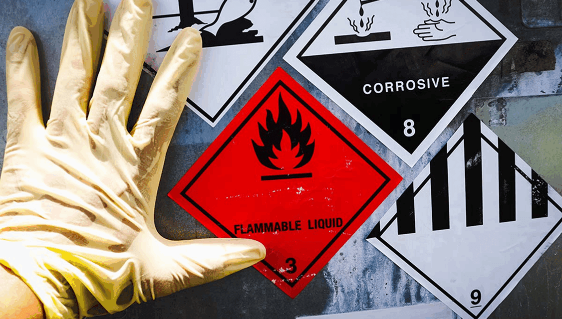 Hand with glove and safety signage