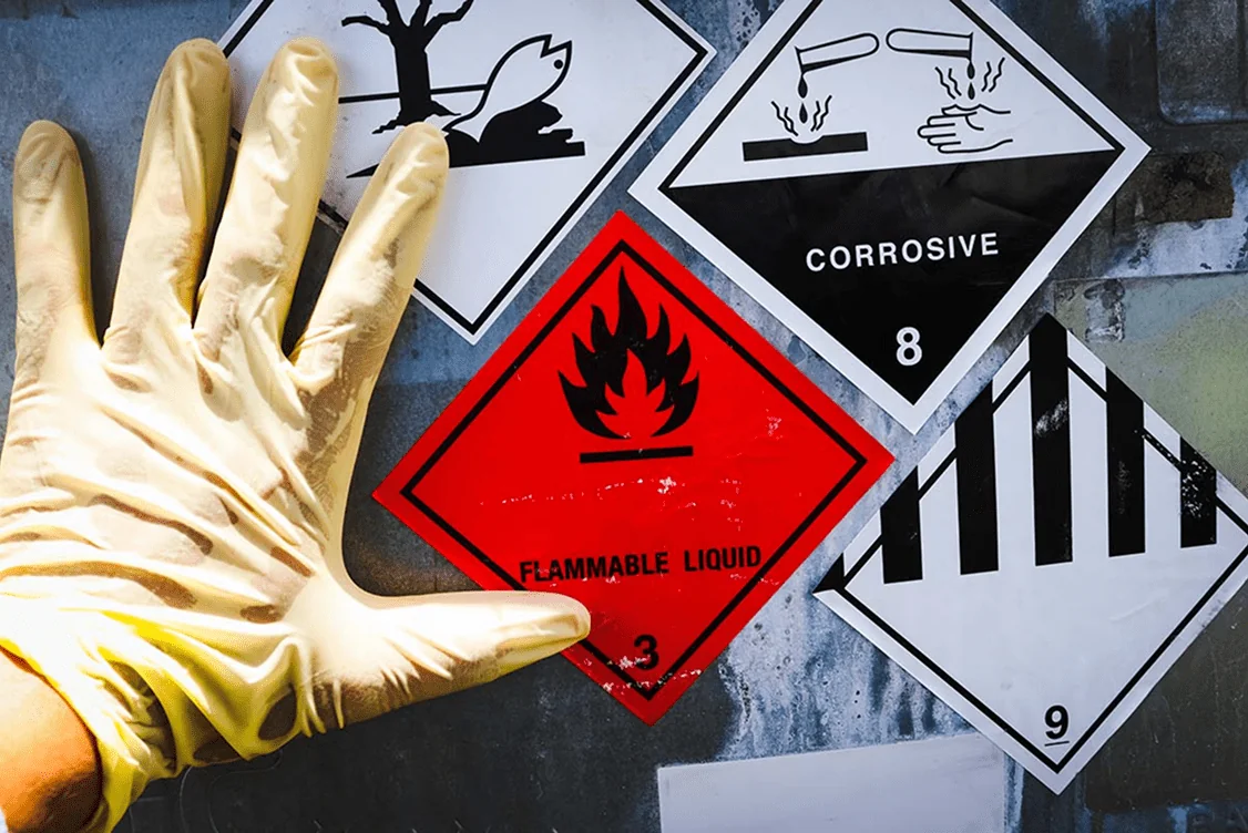 Hand with glove and safety signage