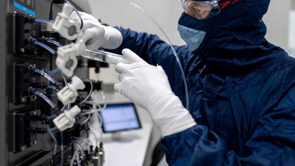 a person in a lab coat holding a white object