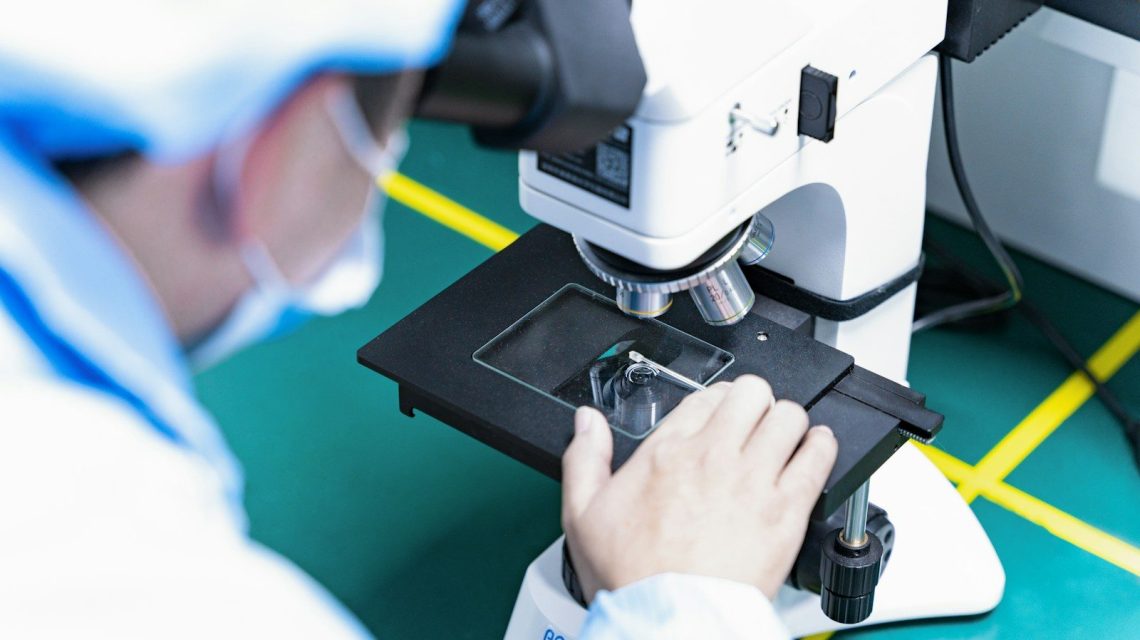 a man looking through a microscope at something