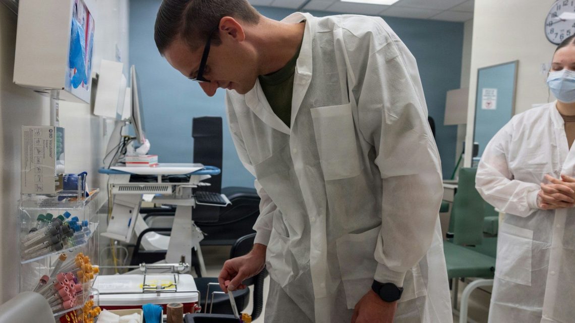 Scientist in lab coat examines sample in laboratory