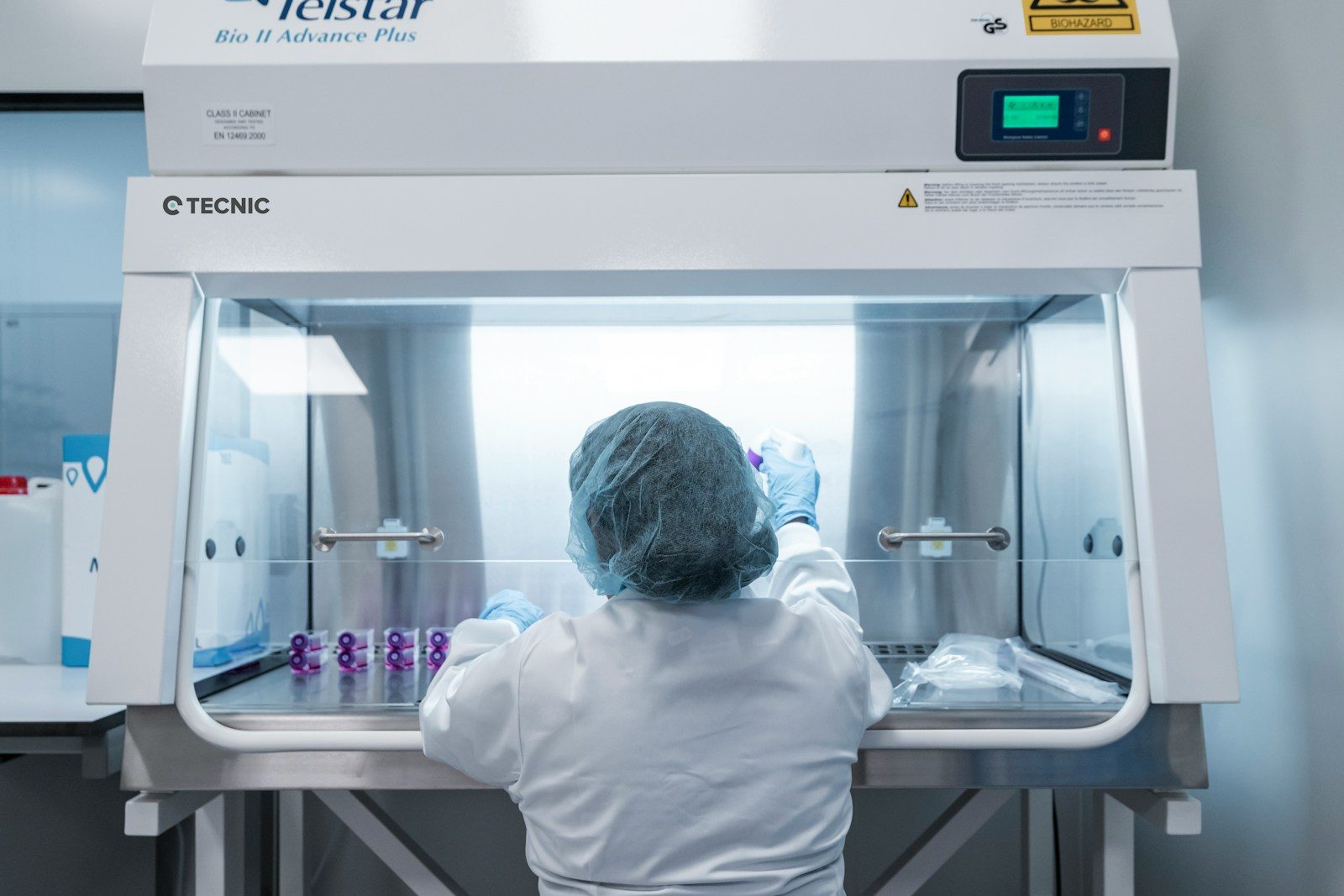 A scientist works in a lab hood, conducting research