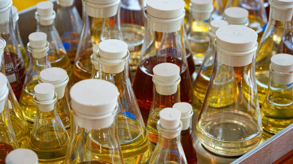 Many glass bottles and flasks filled with colorful liquids